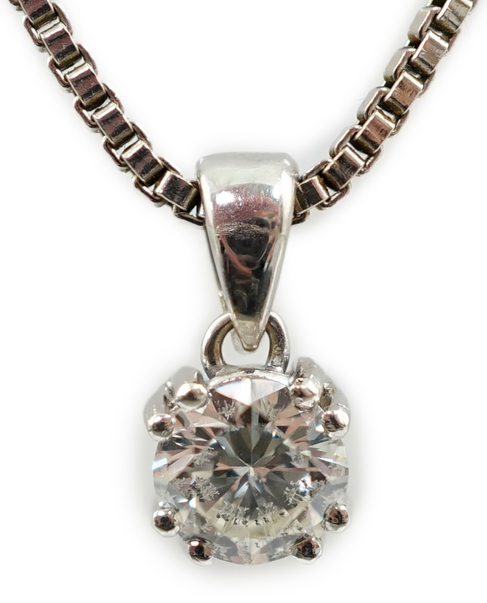 A modern 14k white gold and solitaire diamond set pendant, on a 14k white gold chain